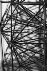 Intricate network of black metal rods creates a mesmerizing geometric display in a contemporary art installation