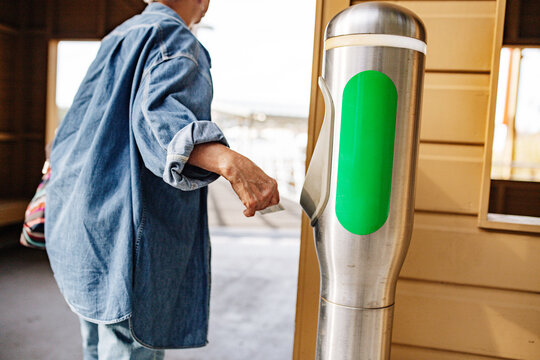 Senior Asian woman walking away from tap off machine