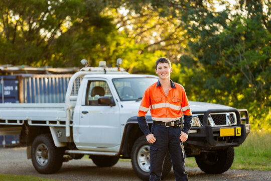 Portrait of young Australian teen apprentice with his ute on Australian farm