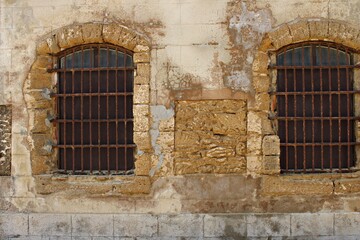 Obraz premium Old windows in Castle of San Sebastián in Cadiz, Andalusia. Spain. Coastal atmosphere that reflects centuries of maritime heritage and architectural decay