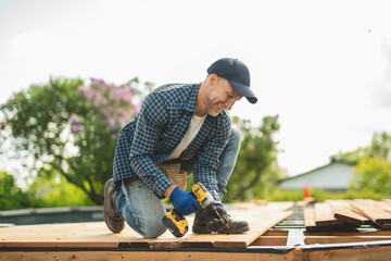 Handyman worker making patio outside close to a pool installing floor.
