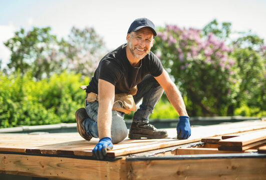 Handyman worker making patio outside close to a pool