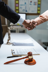 Close up of hands Lawyers explain and discuss matters of law then shakehands after and dealing contract agreement to clients discuss for prepare for the trial. gavel hammer and scales of justice.