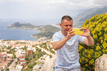 Tourist man caking photos of city of Kas in Turkey from a panoramic viewpoint