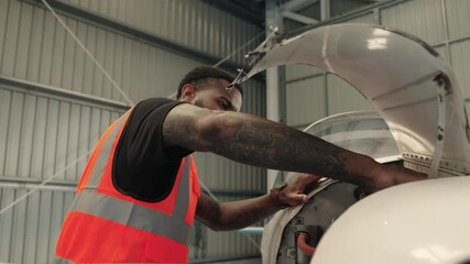 Aircraft maintenance engineer inspecting plane engine in hangar - Powered by Adobe