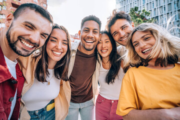 Happy group of friends smiling at camera outside - Diverse young people having fun together on city street - Youth community and people life style concept
