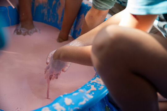 Children hands dripping with oobleck, cornstarch and water mixture, doing a science experiment
