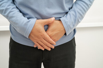 Hernia, Asian man stomach ache, abdominal pain and urology problem health.