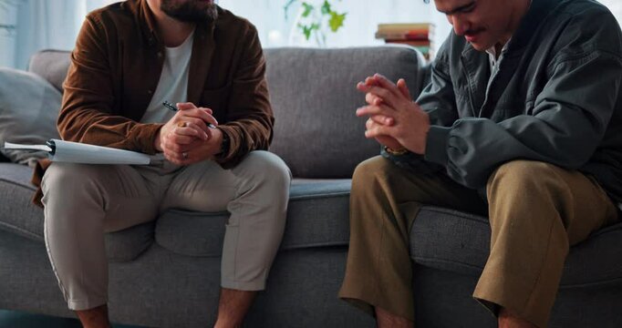 Therapy, writing and men on sofa in office for consulting, counseling session and support. Psychology, mental health and therapist with patient with notes for diagnosis, listening and evaluation