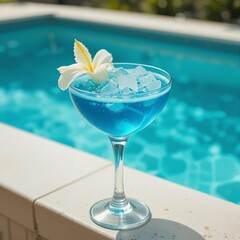 Refreshing blue cocktail garnished with a flower beside a shimmering pool in sunny weather