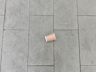 Coffee cup on the cement floor in the city park.