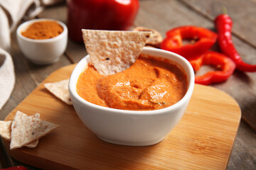 Bowl of tasty muhammara and pita on wooden background