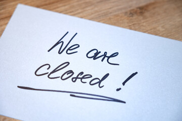 We are closed! White note with handwritten text. Business, retail place, closed, message, information sign.