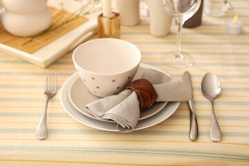 Elegant table setting with folded napkin, bowl and cutlery, closeup