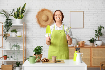 Smiling woman with gardening tools in cozy living room
