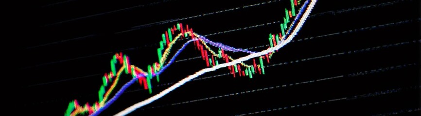 Stock market graph showing upward green lines climbing on glossy black screen, representing financial growth and investment performance