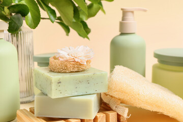 Set of cosmetic products and bath sponge on color background, closeup