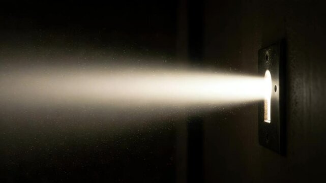 Light beam shining through keyhole in dark environment  