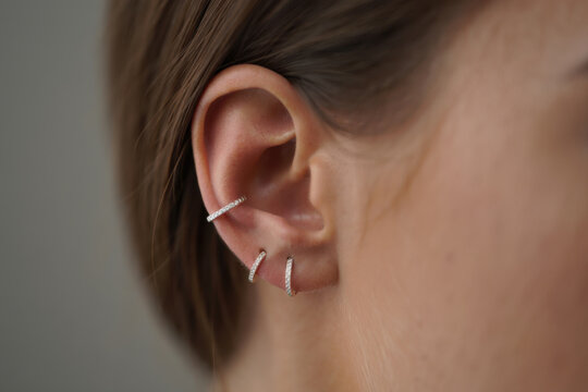 Woman wearing multiple diamond earrings showing pierced ears