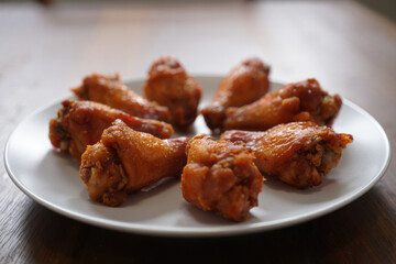 Delicious crispy chicken wings sitting on white plate