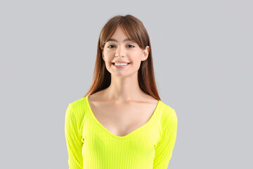Young woman smiling on light background