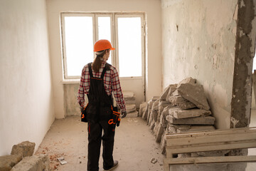 rear view of a builder in an old apartment preparing to renovate a room