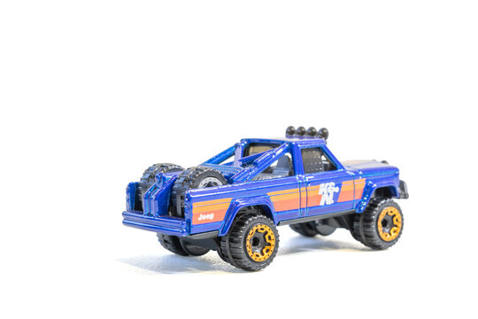 Lins, s&atilde;o paulo, brazil - july 10 2025:  a blue jeep comanche pickup truck toy car with orange stripes on a white background studio shot