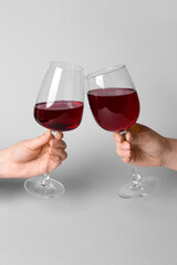 Female hands with glasses of red wine on white background