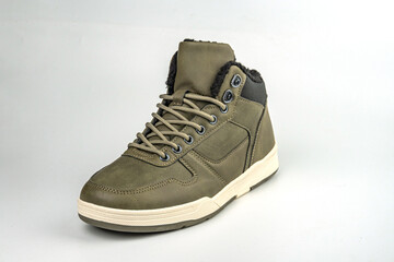 Image shows a rugged high-top sneaker, green and grey in color, possibly made of leather and suede...