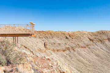 Meteor Crater's viewing platform overlooks the massive geological formation, offering a clear view of the impact crater and surrounding desert in Arizona