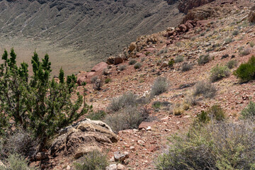 The iconic Meteor Crater in Arizona, showing the central uplift and surrounding basin. Captured on a clear, sunny day.