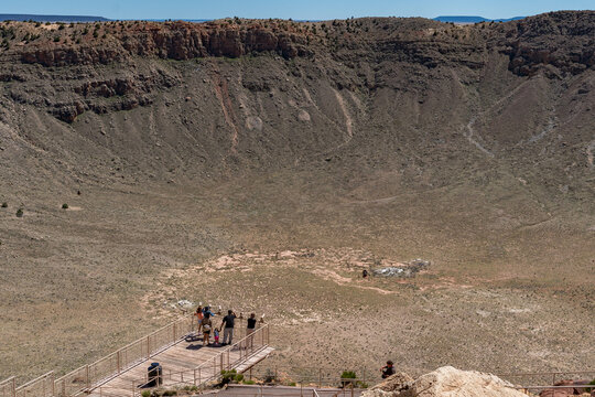 Meteor Crater's rugged terrain in Winslow, Arizona. Steep cliffs and rocky slopes highlight the crater's geological features.