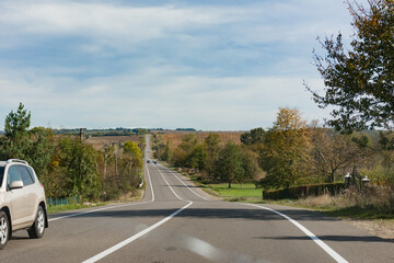 Capturing the essence of a tranquil autumn drive through winding country roads surrounded by...