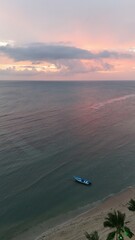 Beautiful cloudy red sunrise over sea with beach, waves and mountains in the background. Impressive structure texture in the sky