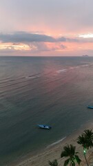 Beautiful cloudy red sunrise over sea with beach, waves and mountains in the background. Impressive structure texture in the sky
