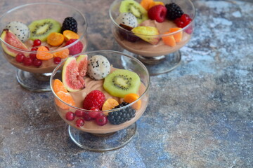 Silken tofu chocolate mousse dessert with mixed fresh fruits ( kiwi, dragon fruit, raspberry, blackberry, fig, orange, red currant, physalis). Vegan dessert