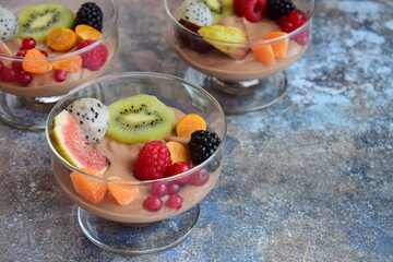 Silken tofu chocolate mousse dessert with mixed fresh fruits ( kiwi, dragon fruit, raspberry, blackberry, fig, orange, red currant, physalis). Vegan dessert