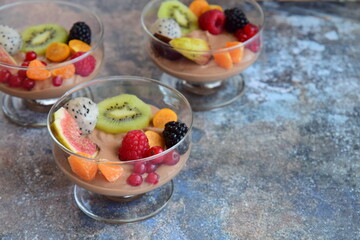 Silken tofu chocolate mousse dessert with mixed fresh fruits ( kiwi, dragon fruit, raspberry, blackberry, fig, orange, red currant, physalis). Vegan dessert