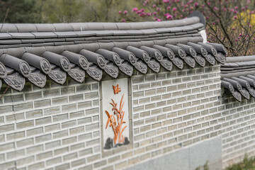 Traditional Japanese chidori-zukuri building with weathered clay roof tiles and stone walls,...