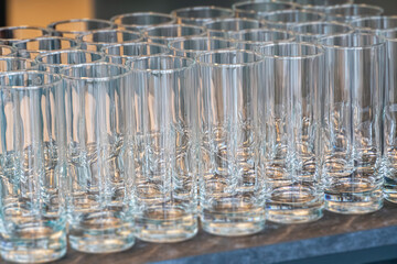 Collection of clear glassware varying in size and shape on a table or countertop, under bright...