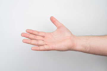 Close-up of a light-skinned, well-defined arm with visible muscle contours, open hand facing upward, slight shadow under the arm, bright lighting, neutral background possibly the floor