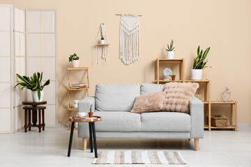 Interior of living room with sofa, shelves and green plants