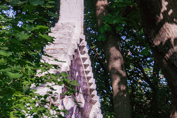 Abandoned stone structure, possibly a tower or fortification, in disrepair with vegetation growth...