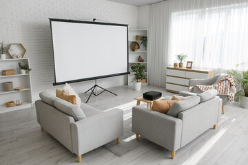 Interior of living room with sofa, armchairs, shelving units and projector screen near white brick...