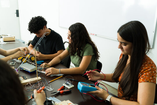 High school students working on electronics project in stem class - Powered by Adobe