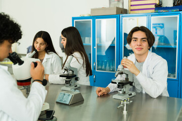Portrait of a high school student using microscopes in laboratory experiment