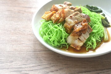 Chinese jade noodles topping roasted crispy pork dipping sweet soy sauce on plate 