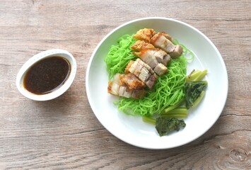 Chinese jade noodles topping roasted crispy pork dipping sweet soy sauce on plate 