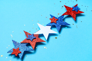 Glitter stars in colors of USA flag on blue background, closeup. Independence Day