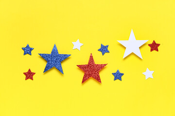 Glitter stars in colors of USA flag on yellow background. Independence Day